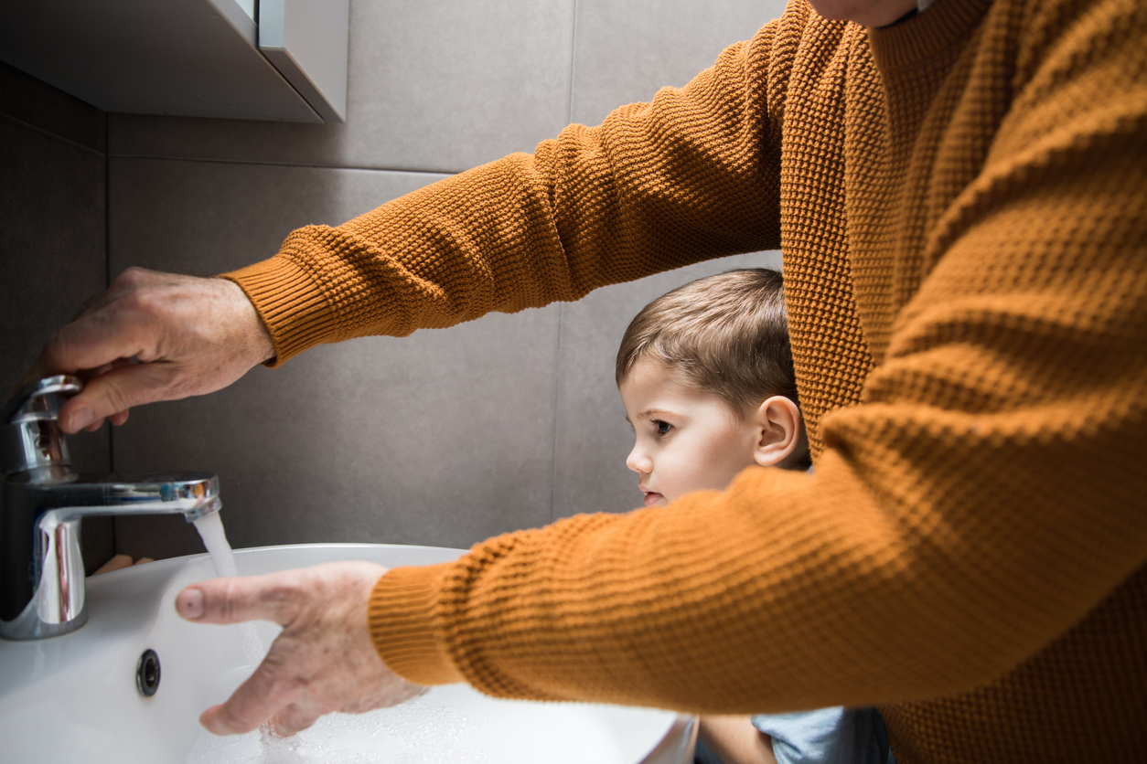 Seniori ja lapsi pesemässä käsiä.